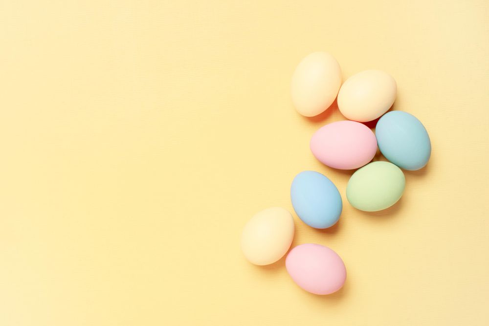 Colorful eggs on yellow background with copy space