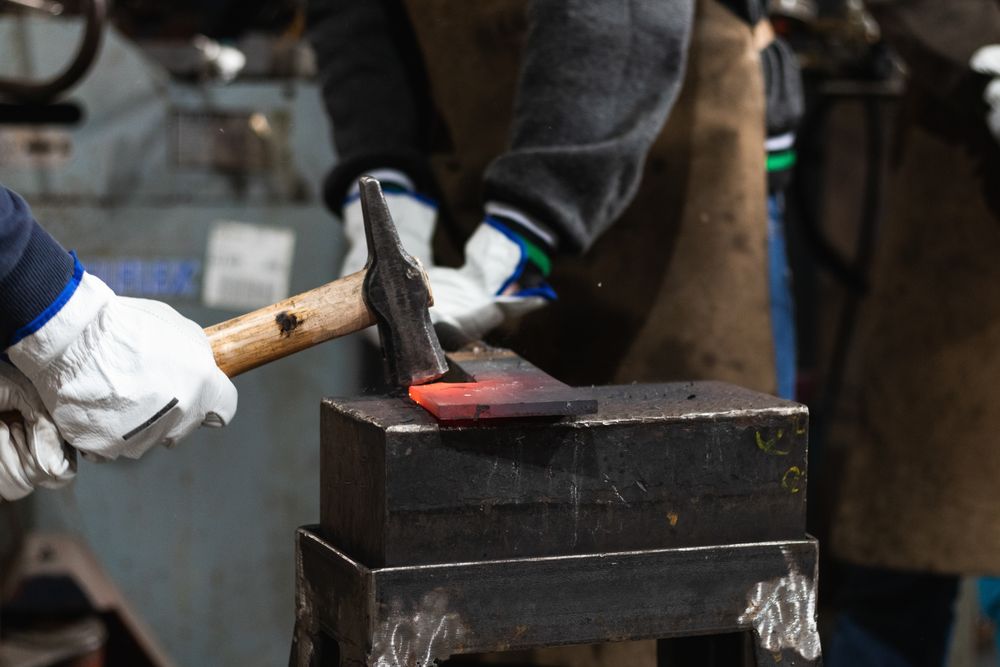Blacksmiths forging hot iron in smithy