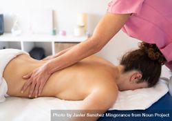 Masseuse massaging side of woman in spa salon 5aXk8P