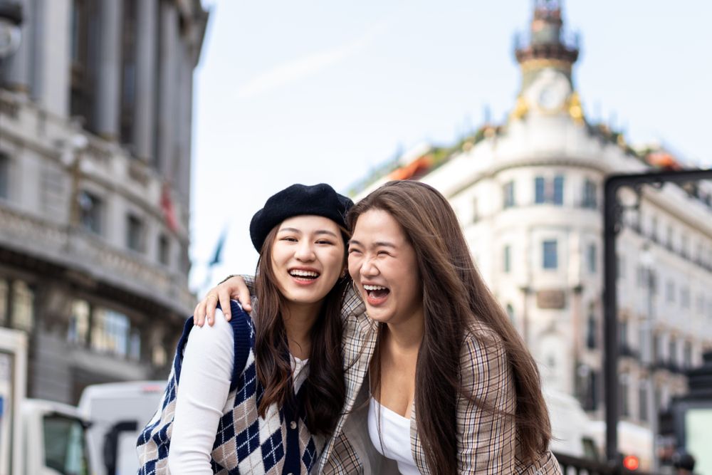 Asian young female friends walking on the street in the city
