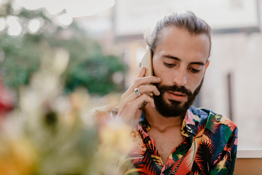 Bearded latino man talking on smartphone and looking away