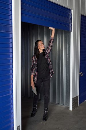 Positive woman opening door of storage