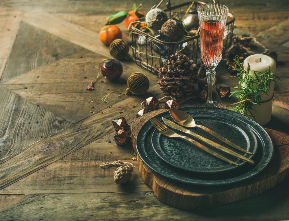 Table setting with crystal flute of Champagne, pinecone, and candle, with copy space