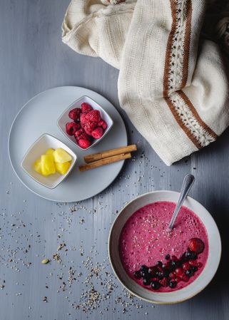 Smoothie bowl with fresh berries and sesame served on table