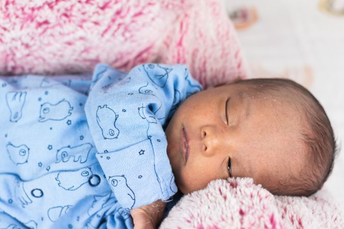 Newborn baby lying on big soft toy