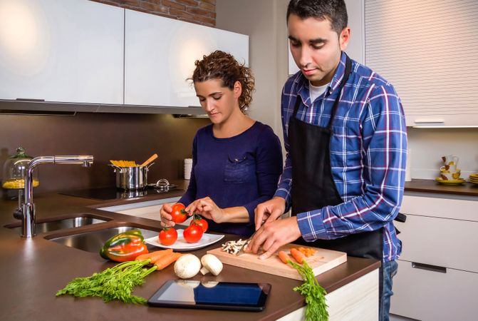 Portrait of couple prepping food together for dinner