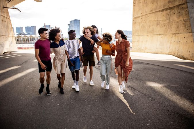 Diverse friends enjoying free time together walking down street