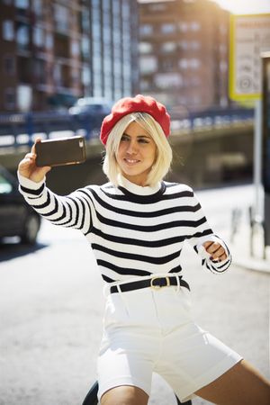 female in red beret taking selfie