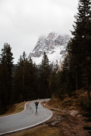 Lonely traveler among pine forest near big cliffs