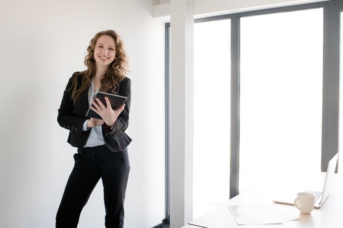 Smiling woman using tablet in office