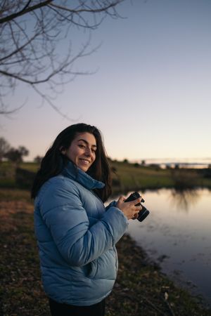 Photographer woman taking photos of a lake at sunset