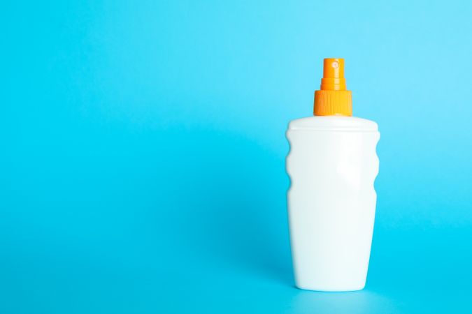 Sunscreen spray on color background, space for text