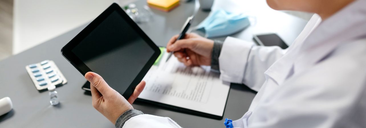 Unrecognizable female doctor using tablet while working