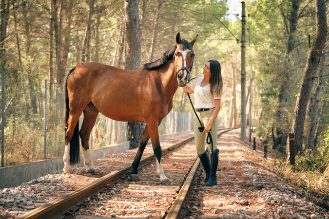 Content woman with horse in woods