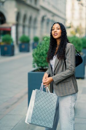 A fashionable and stylish young woman enjoying a fun day of shopping in a vibrant urban setting