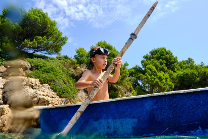 Boy rowing boat on sea