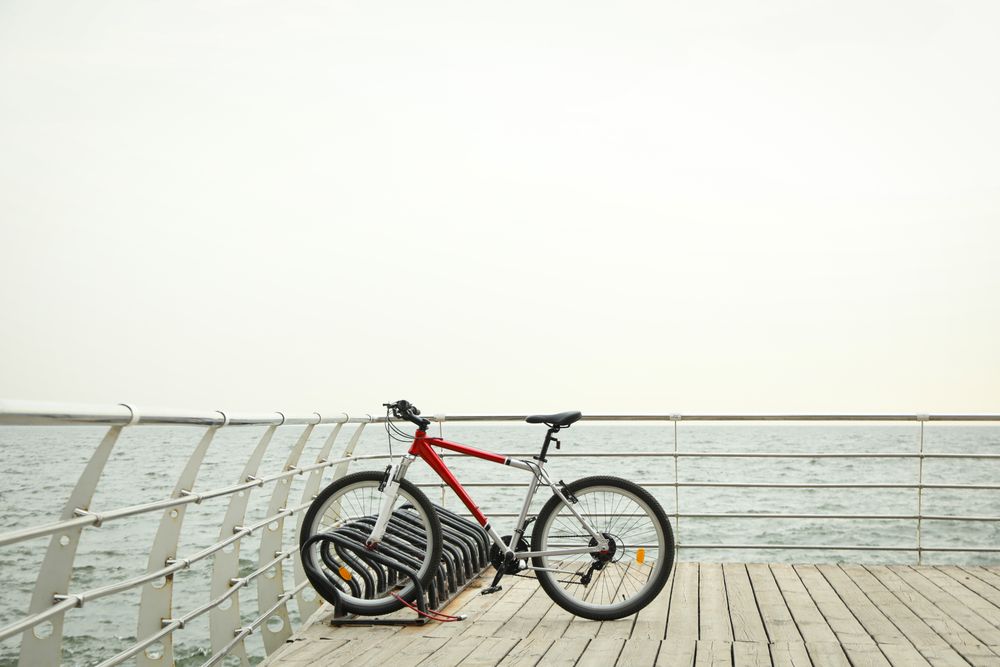 Red bicycle on wooden floor outdoors at sea