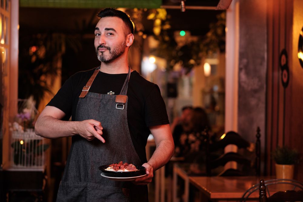 Cheerful waiter serving snack in restaurant