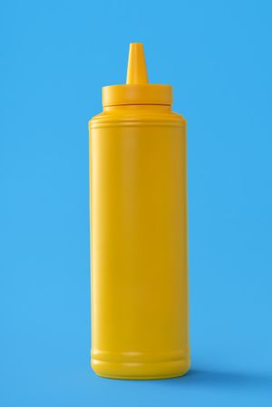 Mustard bottle isolated on a blue background