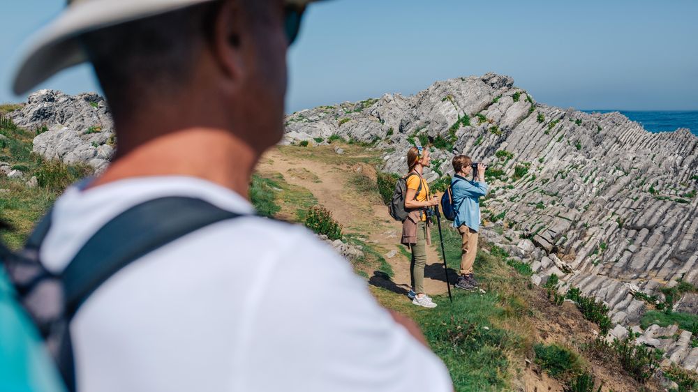 Man in foreground of his family enjoying view while hiking