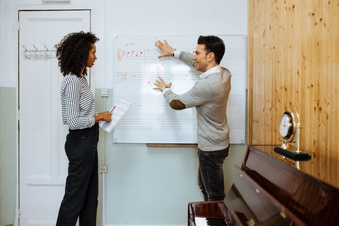 Man teaching woman music notes