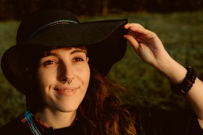 Stylish young woman in felt hat outdoors