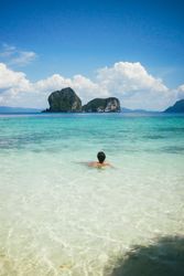 Traveler swimming in turquoise ocean water