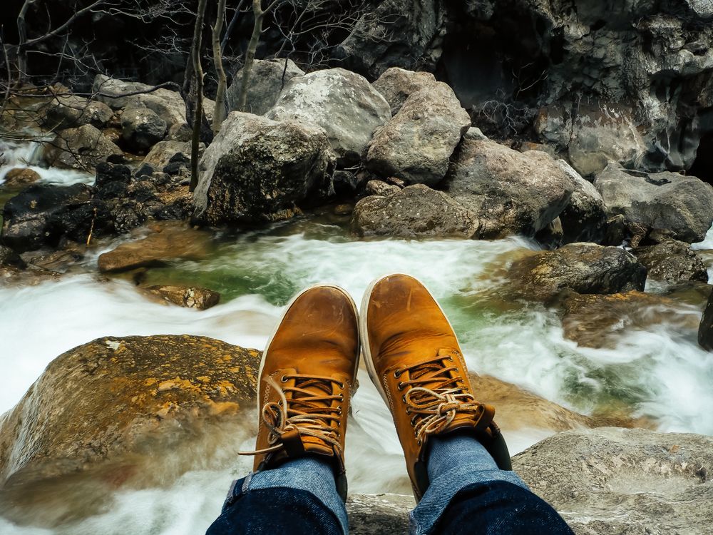 Sitting on top of the rock of the river with rocks and forest in soft-focus in the background of Plitvice Lakes National Park, Croatia.
