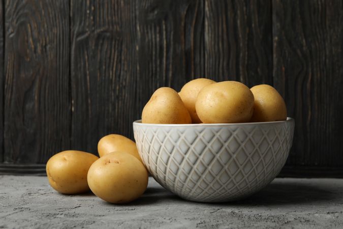Side view of bowl of potatoes in dark kitchen