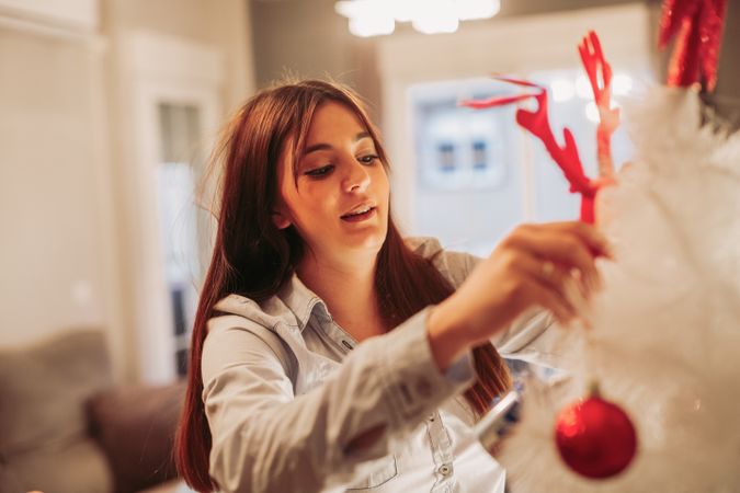Woman arranging Christmas tree
