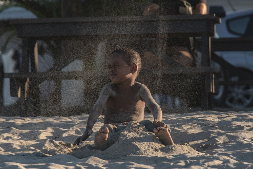 Young boy playing with sand on the beach