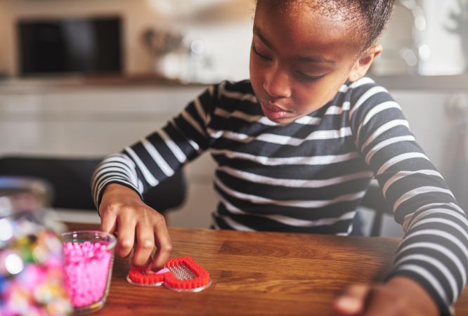 Black girl doing arts and crafts at home