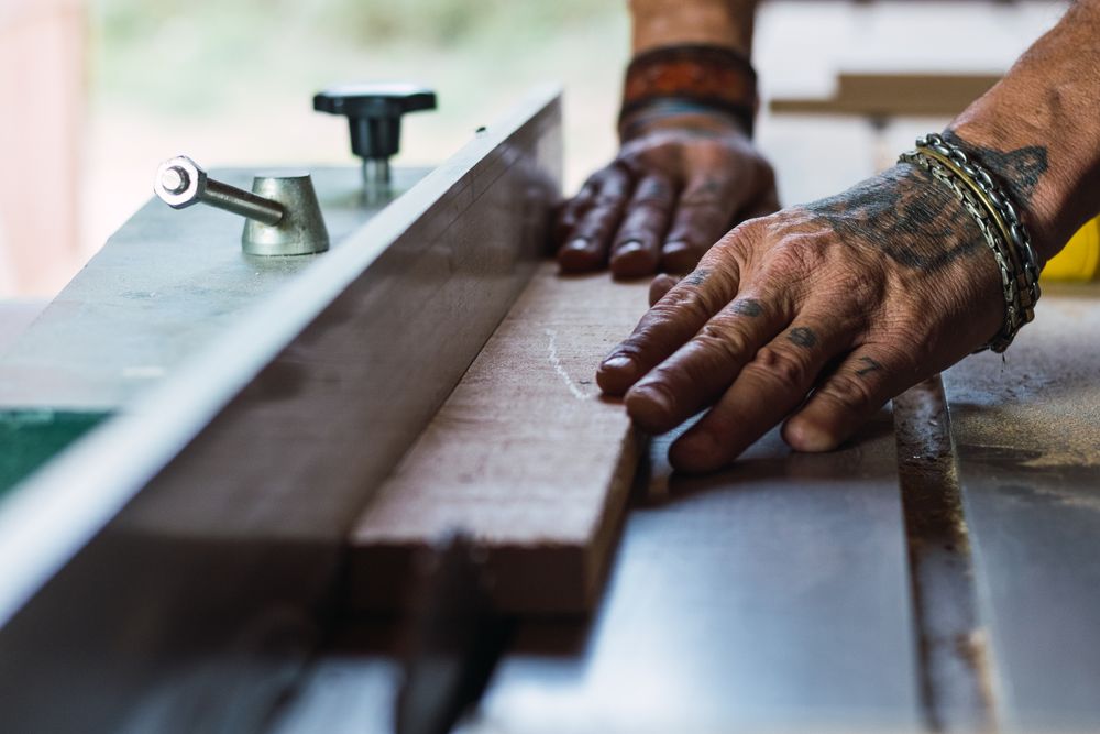 Crop male carpenter cutting wood with circular saw