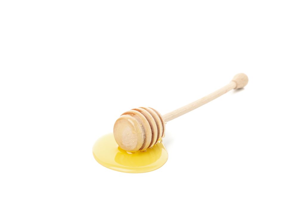 Single dipper used for honey in bright room