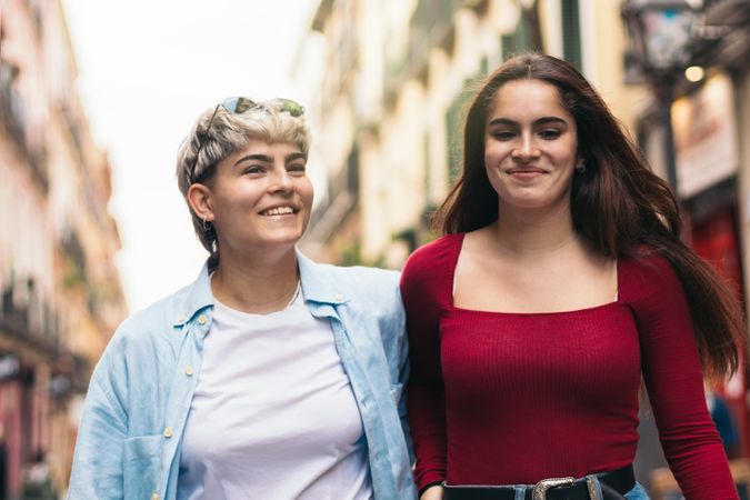 two women walking and smiling on a street