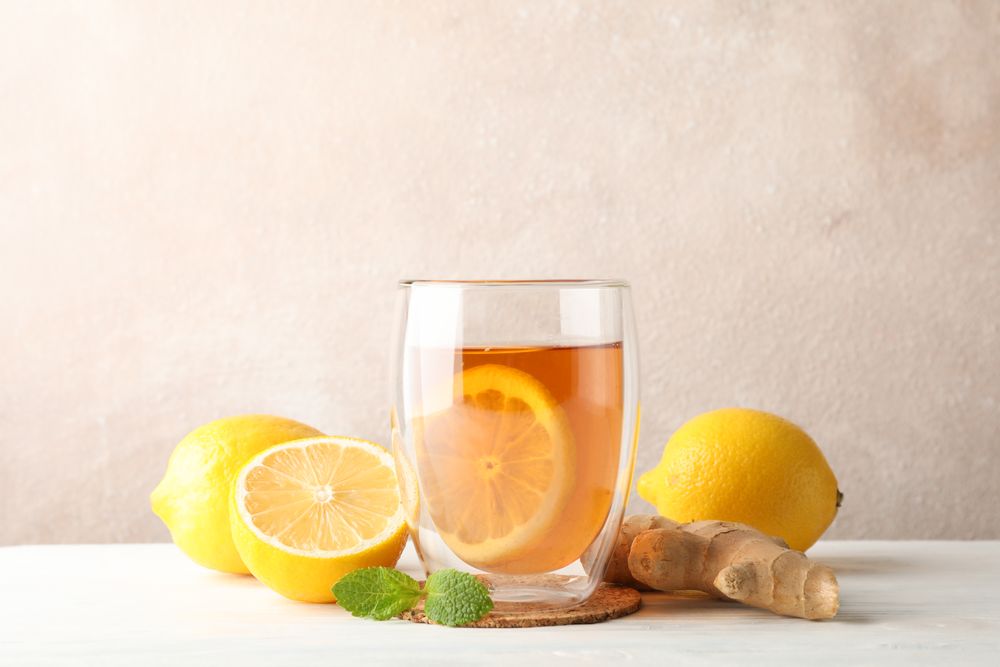 Glass of tea with lemon, mint, honey, dipper and ginger on wooden background ,copy space