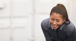 Happy woman in workout gear leaning down