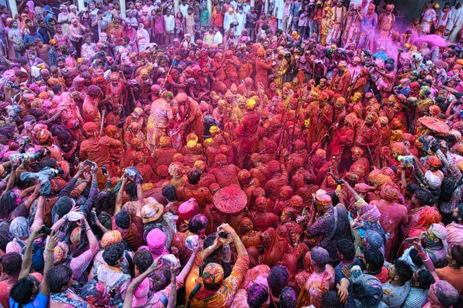 Crowd of people covered with bright color paintings as a ritual in celebrating Holi