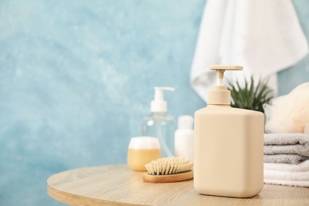 Bottle for liquid soap on wooden table. Personal hygiene concept