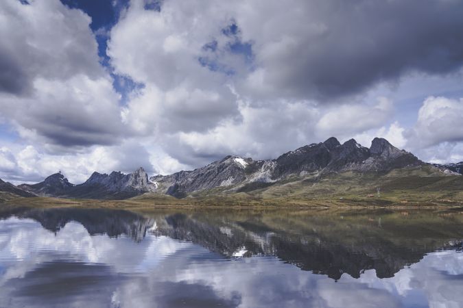 Cloudy sky over calm lake and mountains
