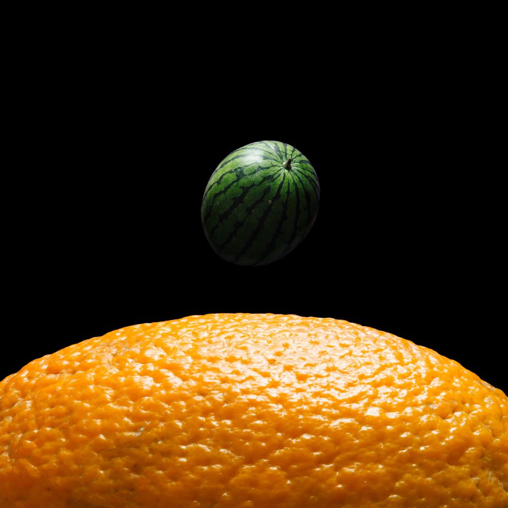 Space scene with orange and watermelon in place of the earth and moon