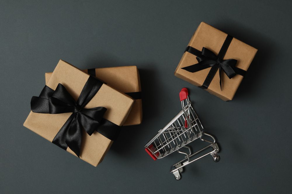 Gift boxes and shop trolley on gray background