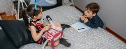Children playing and doing homework talking with their mother who works at home