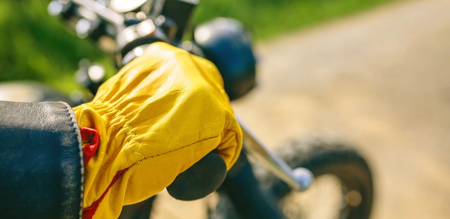 Biker's hand with gloves grabbing the handlebar