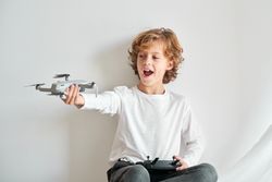 Positive boy with drone in studio