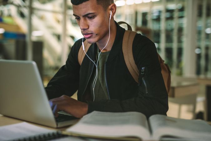 Young male student preparing school assignment on computer laptop