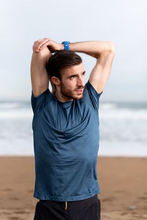 Sportsman warming up to train at beach