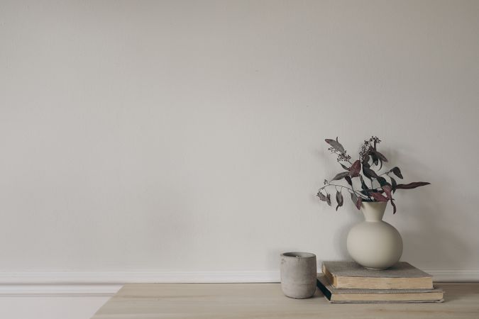 Modern vase with dry eucalyptus tree branches on wooden table