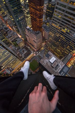 Man sitting on top of building looking down