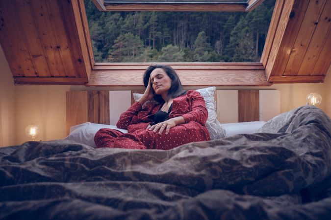 Calm woman sleeping on bed on cottage in mountains